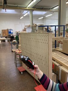 Hand mit mobilem Aufnahmegerät vor einer senkrecht aufgestellten Windlade